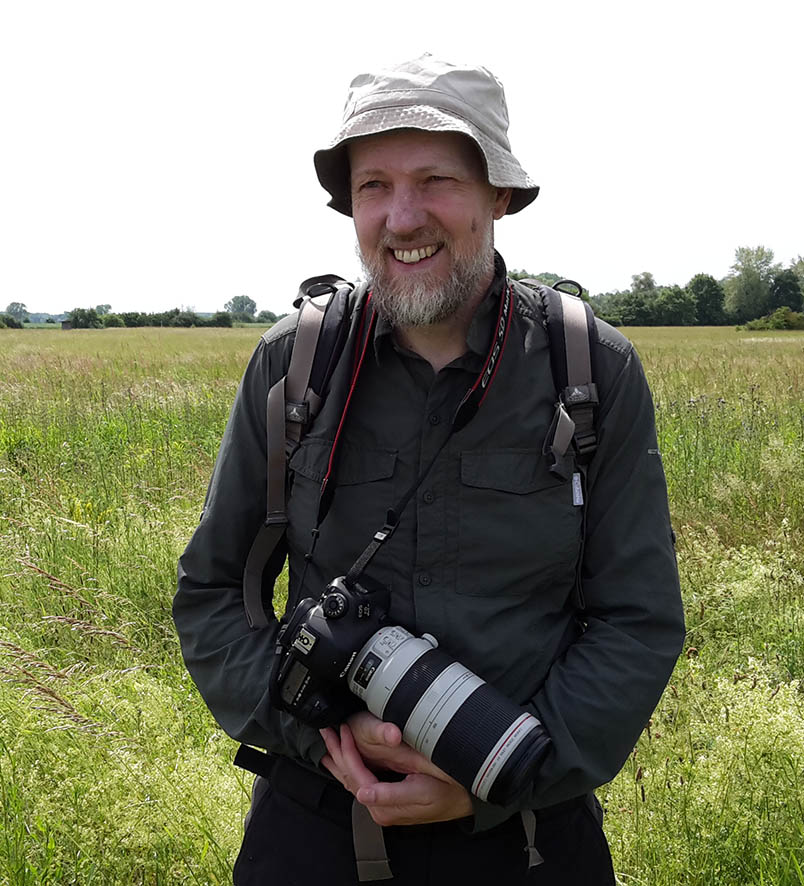 Photo of Mike Dodd in a field holding a camera