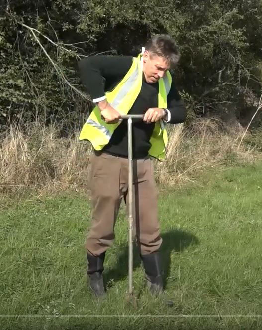 Image of a person taking a soil sample from a field