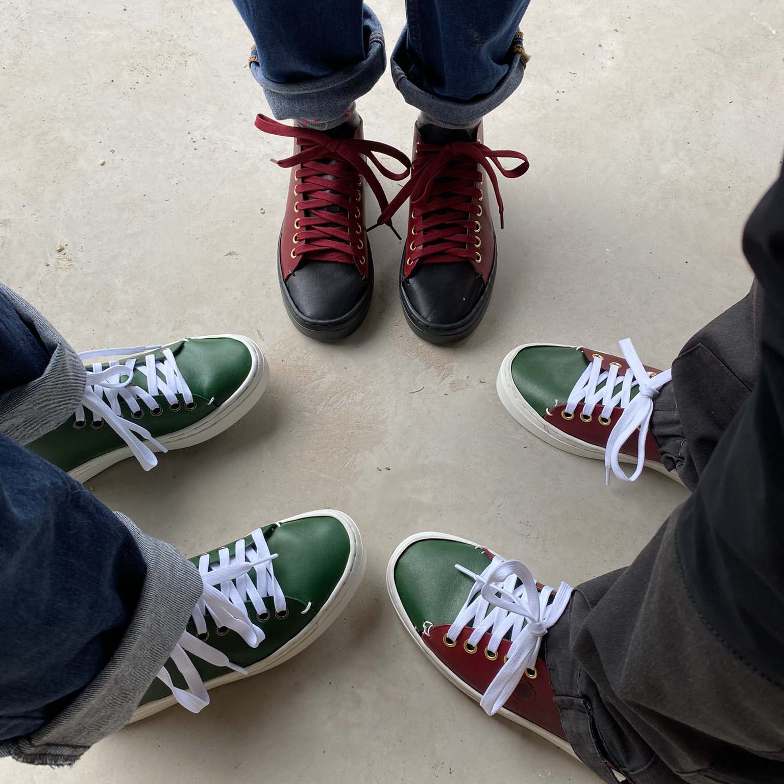 Three pairs of feet wearing colourful handmade farm sneakers 