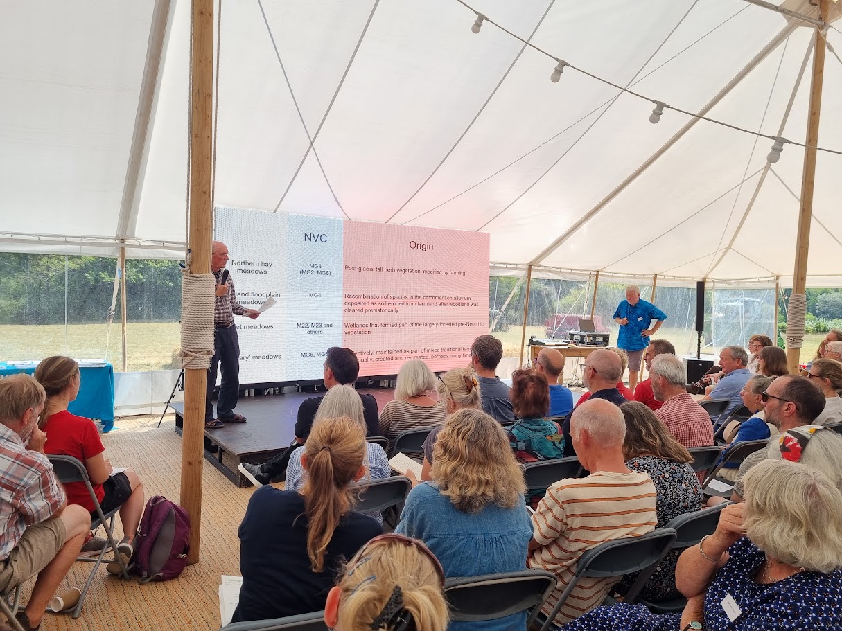 A group of people watching a speaker in a marquee