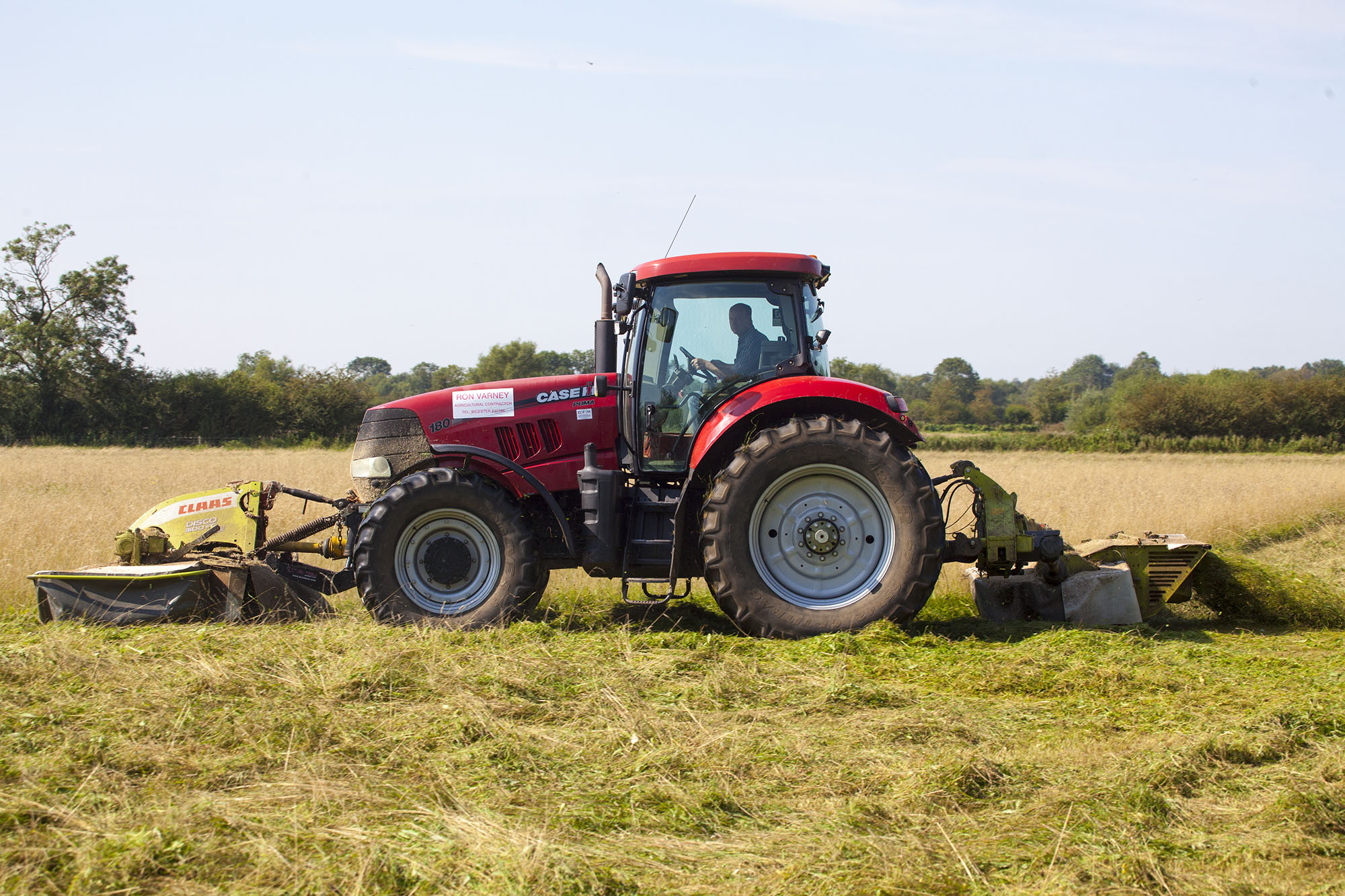 A tractor cutting grass in a field