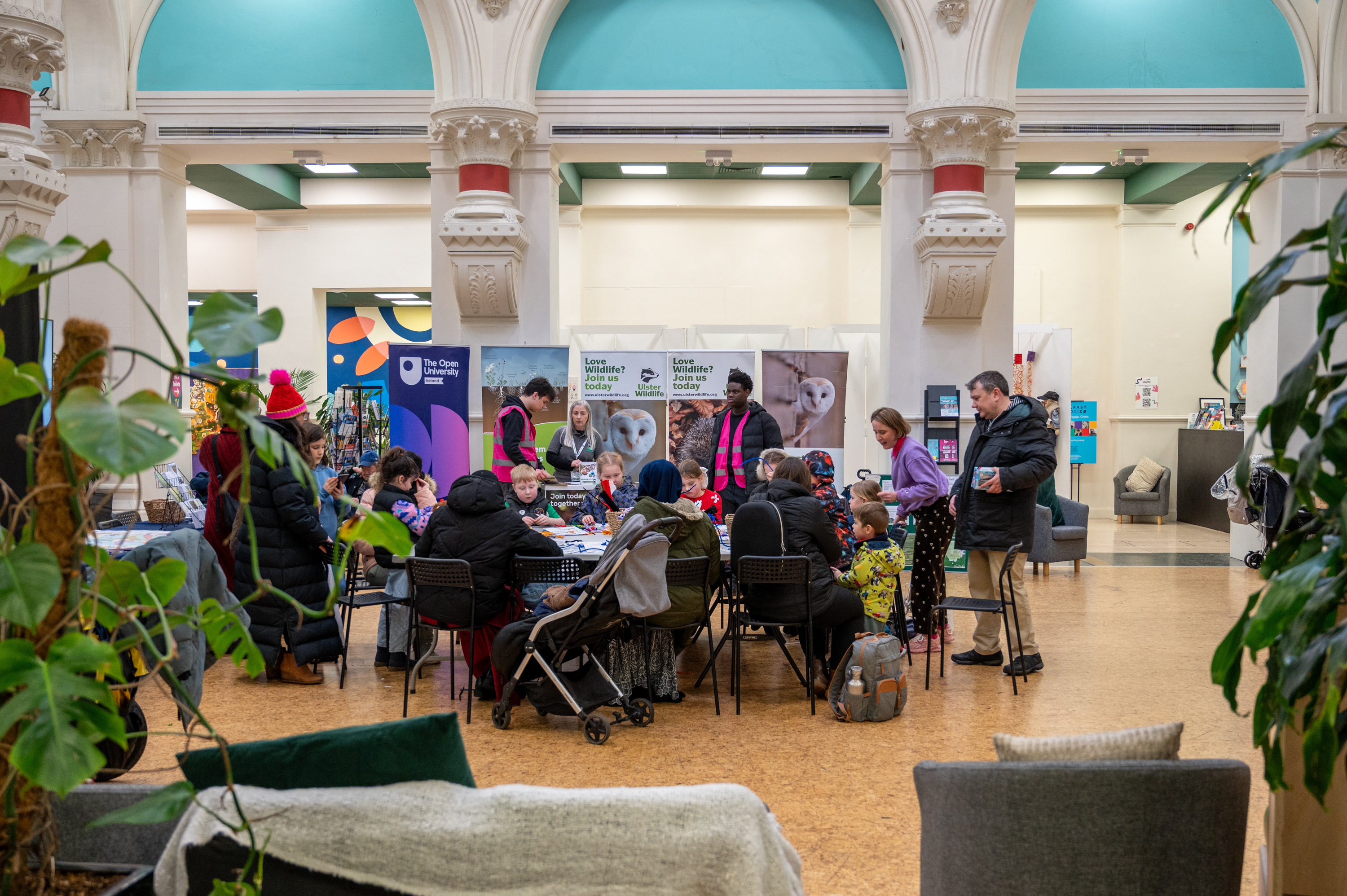 A group of people around a table making pipecleaner animals and plants