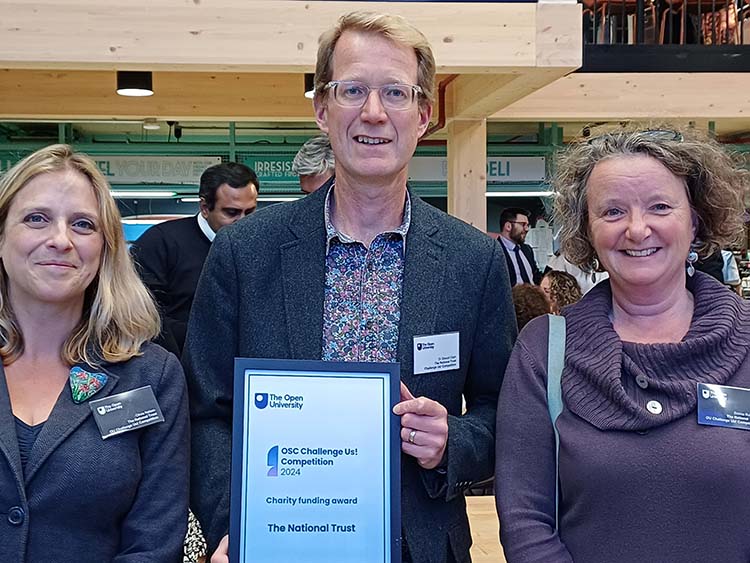 Three people holding a certificate